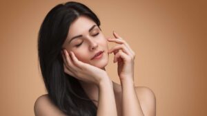 A woman with radiant, glowing skin, showcasing enhanced facial contours, exuding confidence and elegance against a softly lit background.